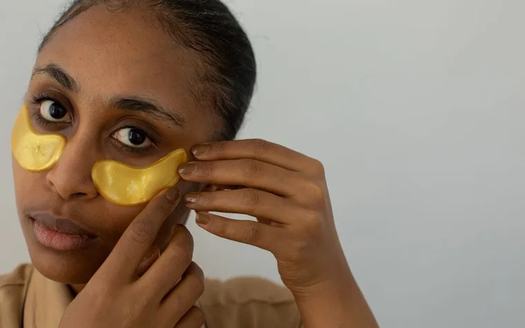 Close-up of a hand applying an under-eye hydrogel patch