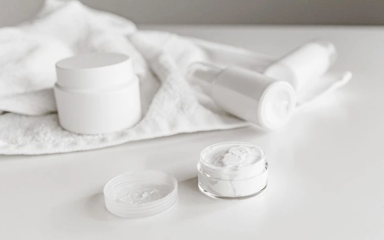Minimalist skincare product jars arranged on a white towel