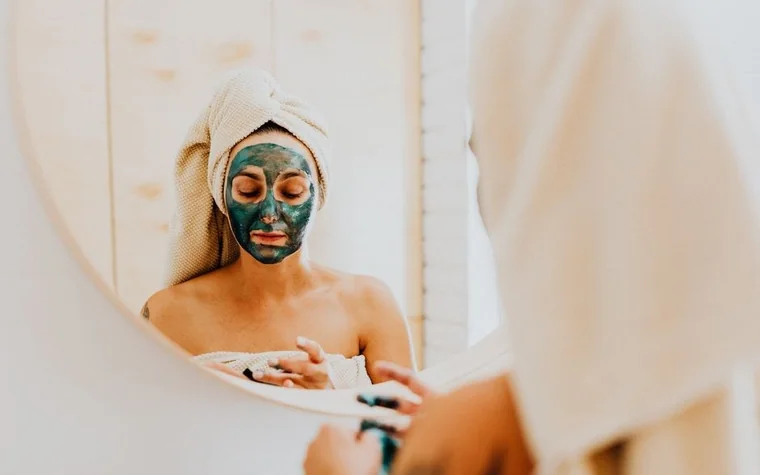 A woman enjoying a calming skincare routine with a face mask