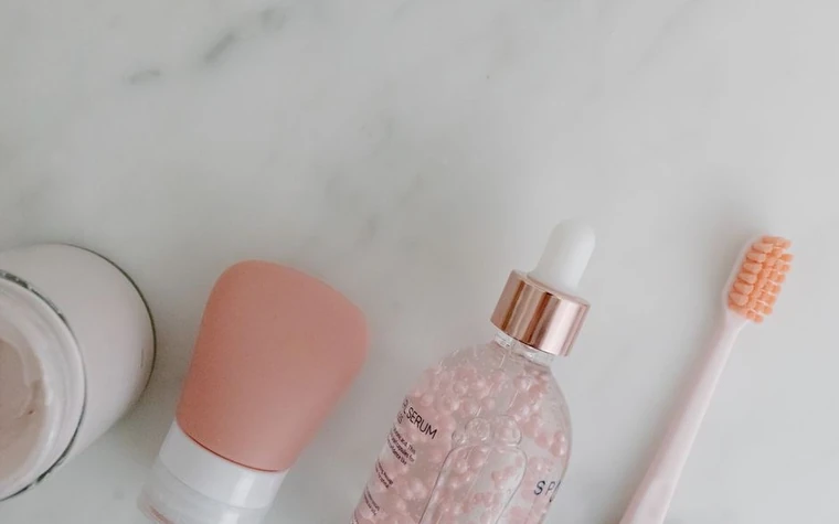 A tube of retinol cream next to a small dropper bottle on a bathroom counter