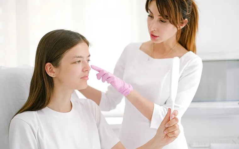 A woman receiving a facial consultation from a skincare professional