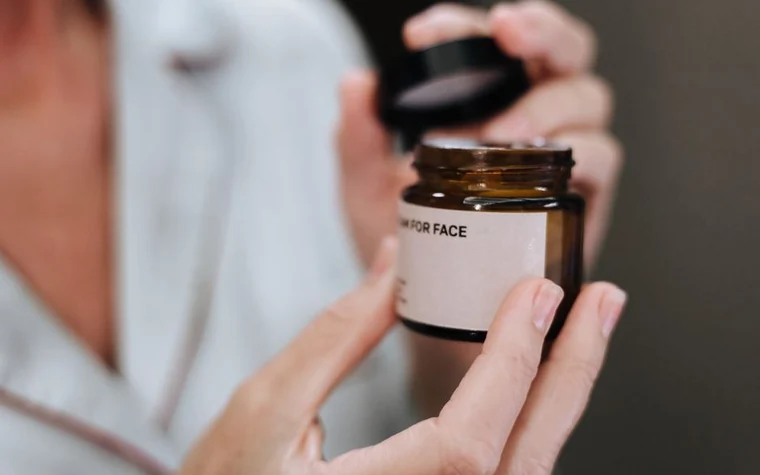 Hands opening a jar of face cream