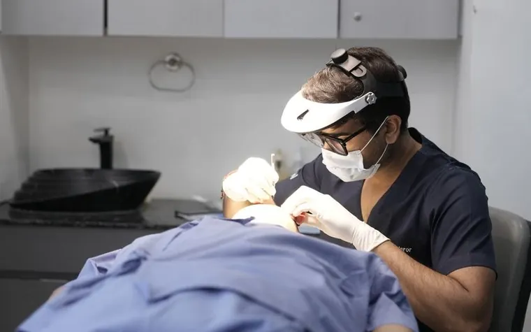 A dermatologist performing a skin procedure on a patient in a clinic