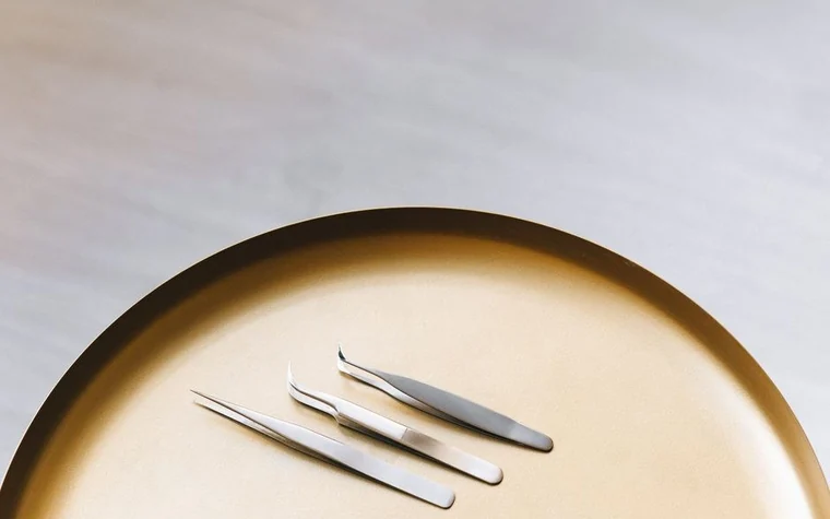 Stainless steel skincare extraction tools arranged on a tray