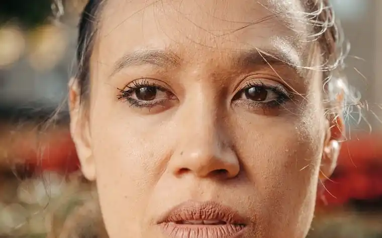 A close-up of a woman's face showing natural skin texture