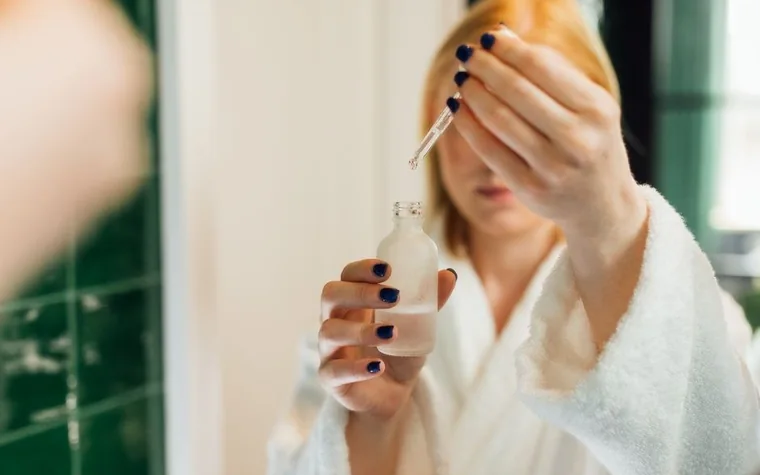 A dropper bottle of serum on a bathroom shelf