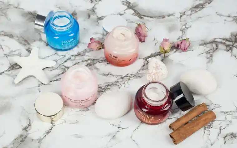 Skincare cream jars arranged on a marble surface