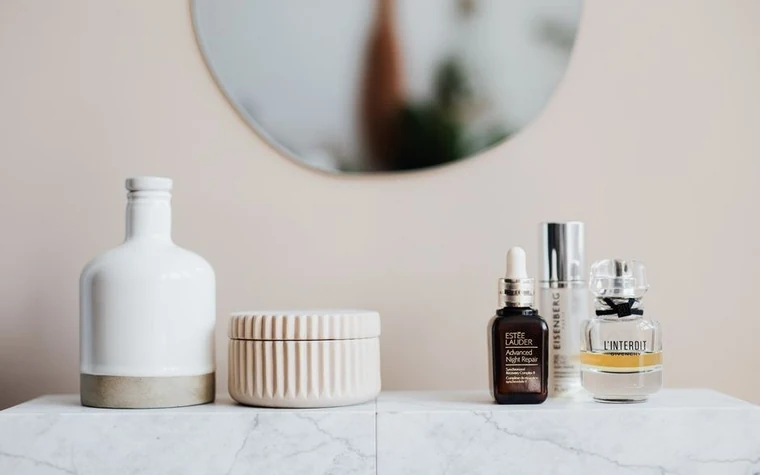 Skincare serum dropper bottle with a droplet on light skin