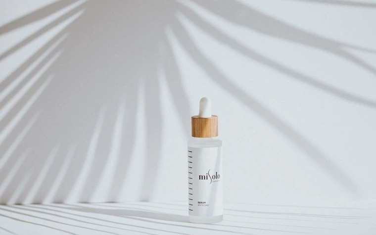 An elegant dropper bottle serum with soft shadow on a light background