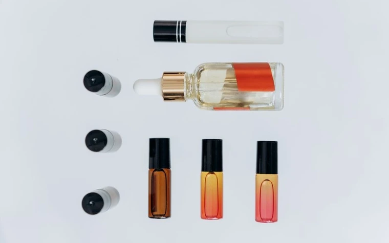 An elegant flat lay of amber dropper bottles and a pipette on a marble surface