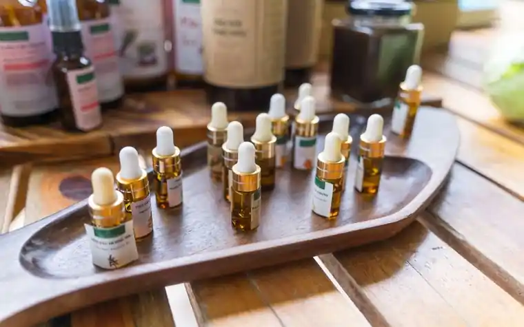 Small dropper bottles of skincare actives arranged on a wooden tray