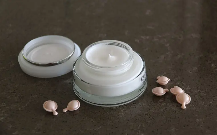 An open jar of face cream on a dark textured surface