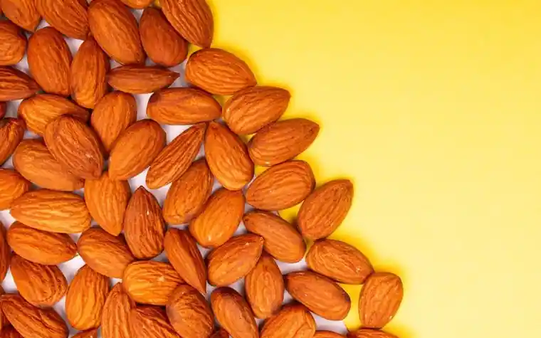Almonds scattered on a yellow background