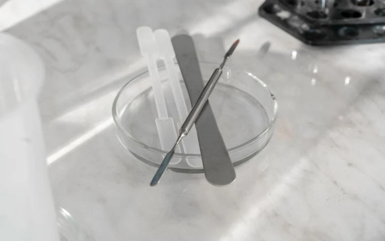 A dropper releasing a drop of gel onto a surface
