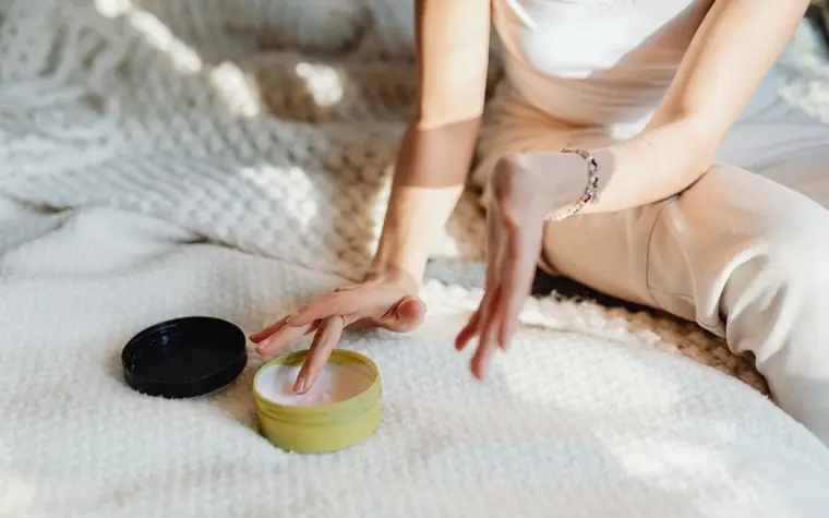 A hand applying cream to skin