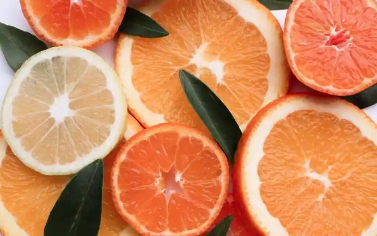 Colorful citrus fruit slices arranged with green leaves