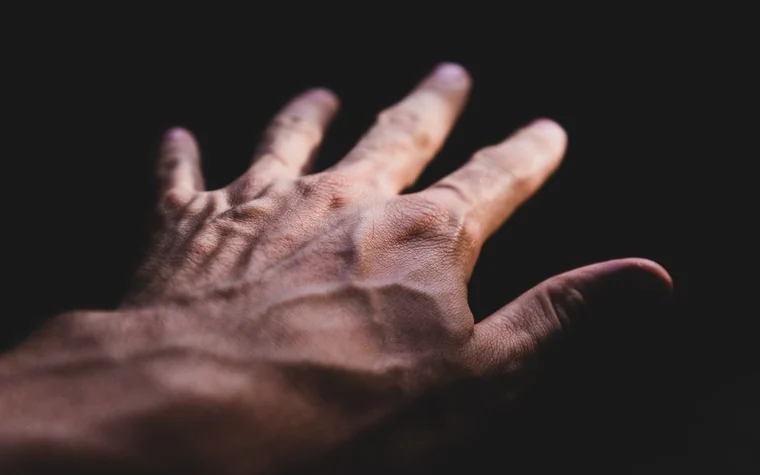 Close-up of the back of a hand showing skin texture in dramatic low light