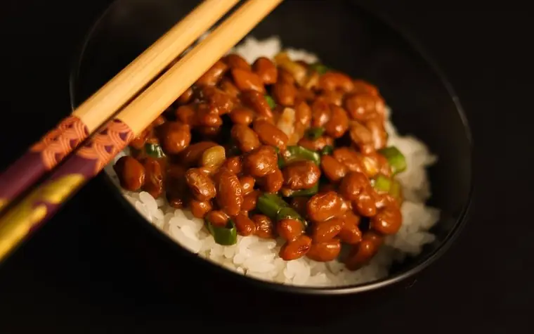Bowl of fermented natto beans served over rice with chopsticks