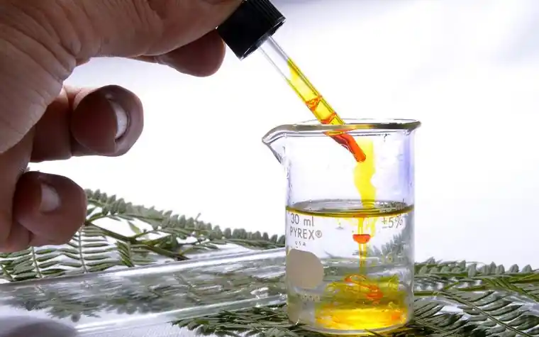 Close-up of a dropper adding gel to a beaker