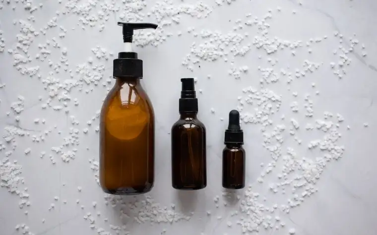 Three amber glass serum bottles arranged on a white surface