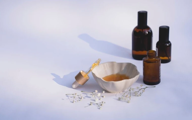 Minimalist display of amber glass dropper bottles and a ceramic dish