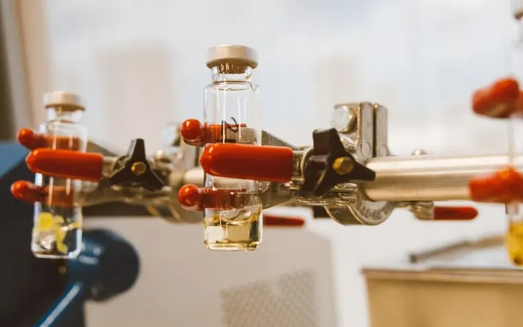 Close-up of laboratory glass vials held by a clamp