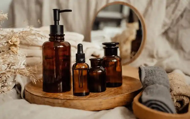 Amber skincare bottles arranged together on a wooden tray