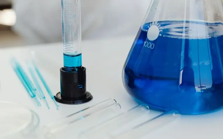 Laboratory glassware with clear liquid on a white bench