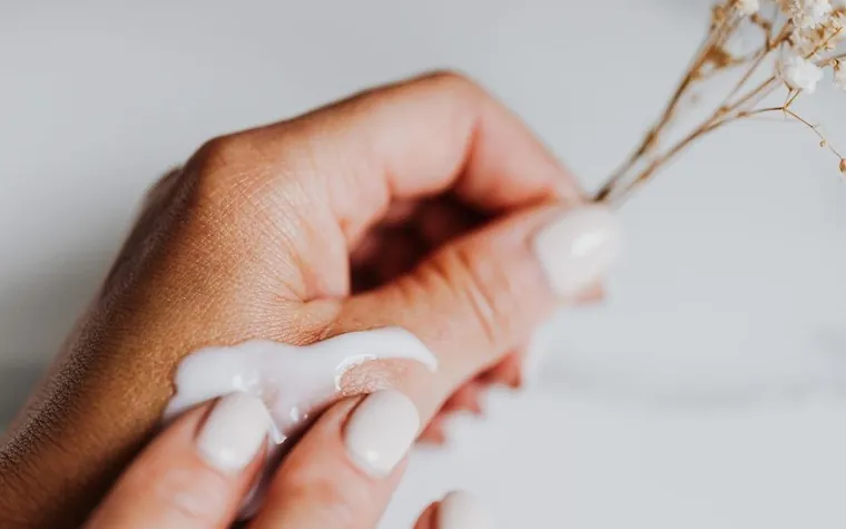 A fingertip with a smear of white cream