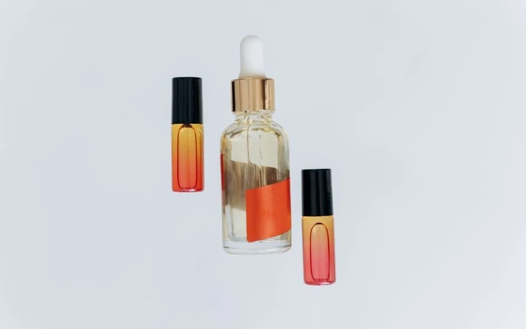 Glass serum bottles with droppers standing on a plain background