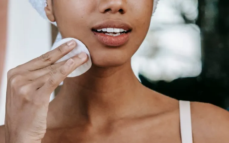 Cotton pad soaked with toner applied to skin