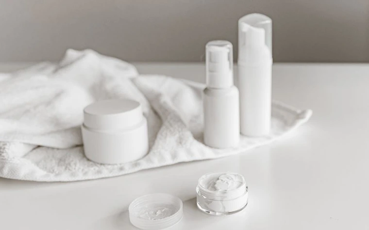 Skincare bottles arranged on a minimalist bathroom shelf