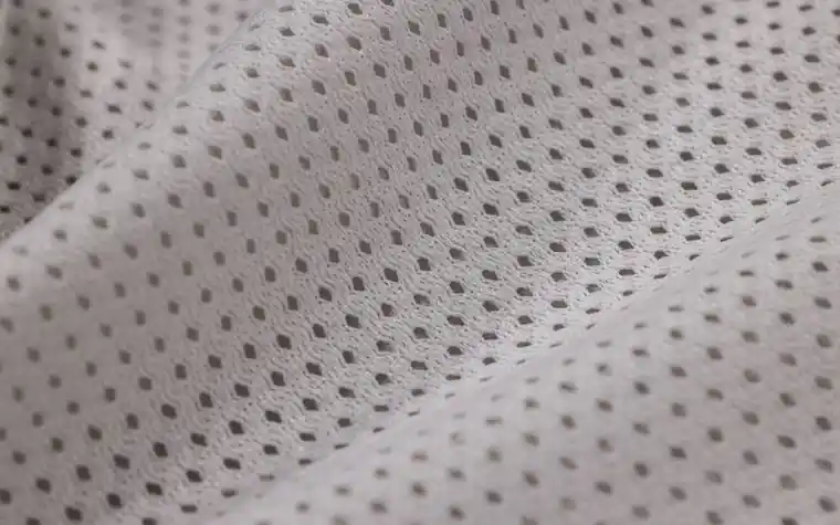 Macro close-up of woven fabric texture similar to a sheet mask material