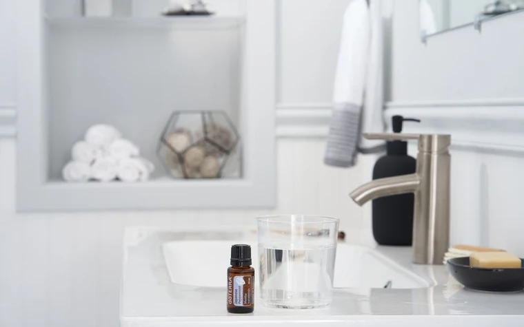 A bright bathroom sink with skincare bottles on the counter
