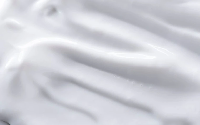 A close-up of smooth white cream texture spread across a surface