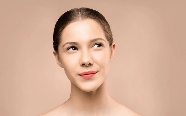 A young woman with radiant, healthy-looking skin looking upward