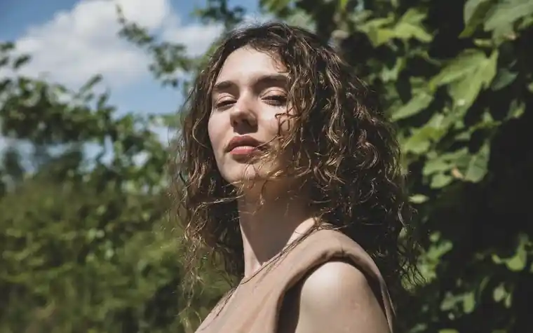 Close-up portrait of a woman's face in dappled natural sunlight