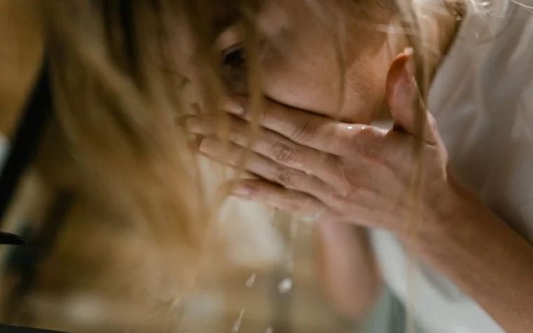 Woman splashing water on her face while washing