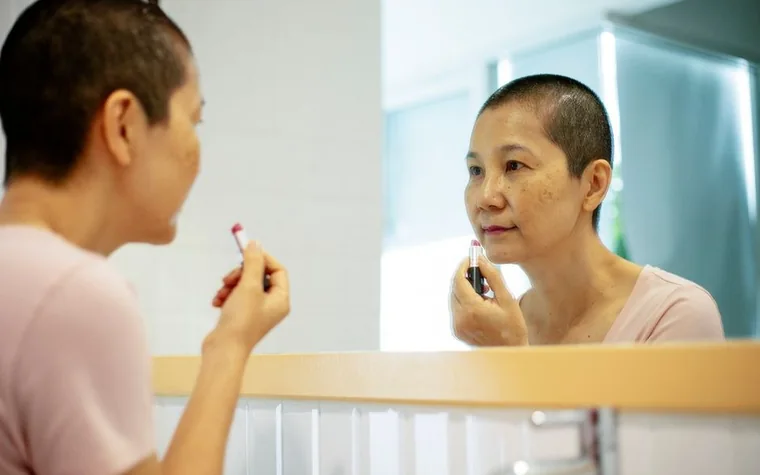 A middle-aged woman looking at her reflection in a bathroom mirror