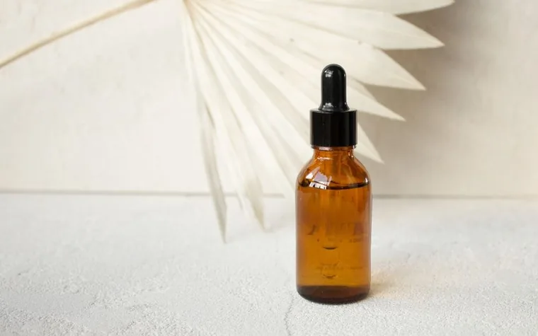 A minimalist amber dropper bottle on a neutral background