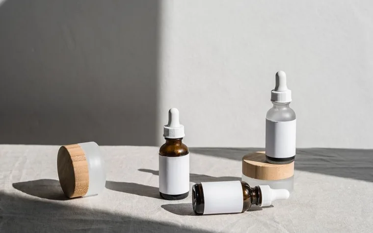 A dropper bottle of clear skincare serum on a light surface