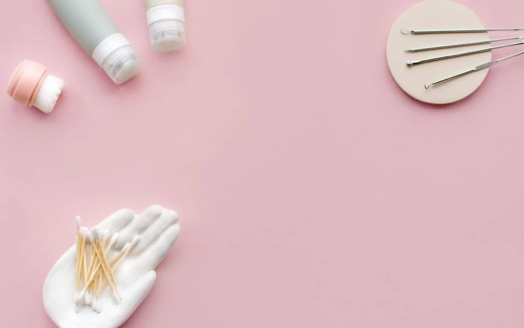 A minimal flat lay of pastel skincare products and cotton swabs