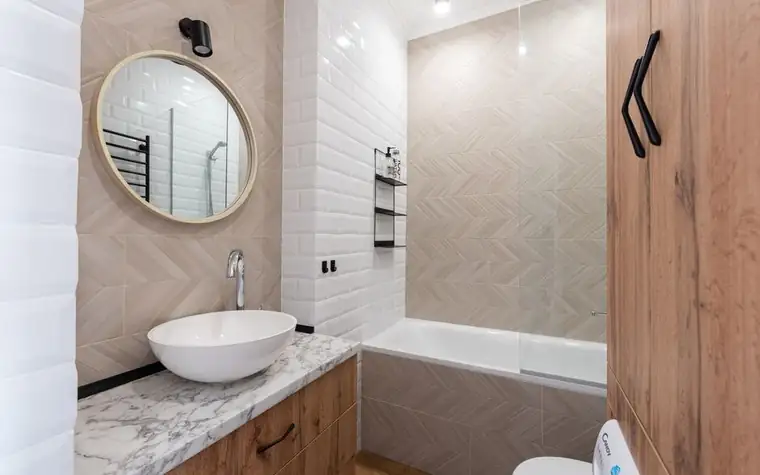 A bright, minimalist bathroom vanity with a round mirror