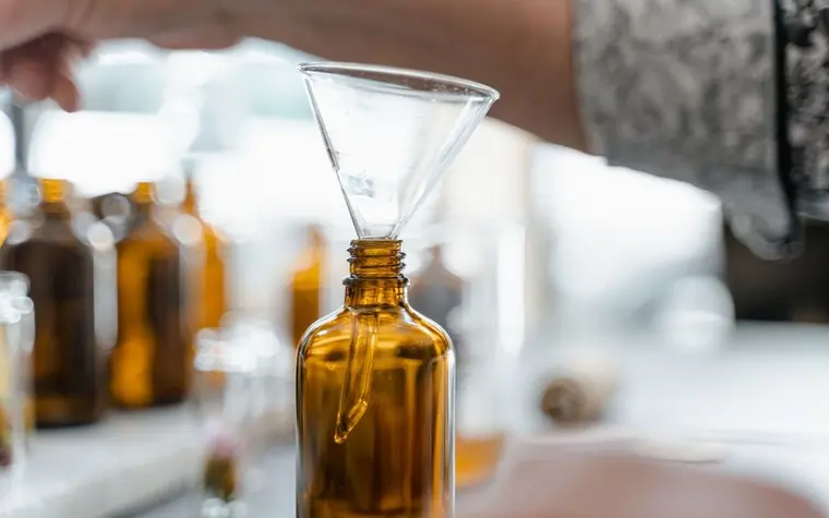 A funnel and amber glass dropper bottles on a counter
