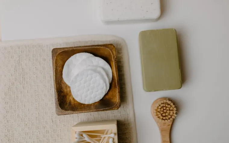 Flat lay of cotton pads and a cleansing bar arranged on a bathroom counter