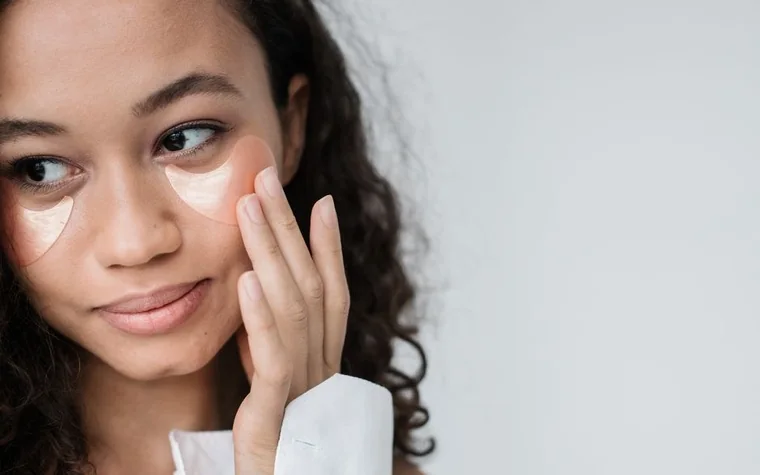 Close-up of a woman applying moisturizer under her eye with her fingertip