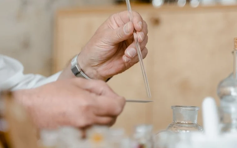 Close-up of hands using a pipette with laboratory glassware