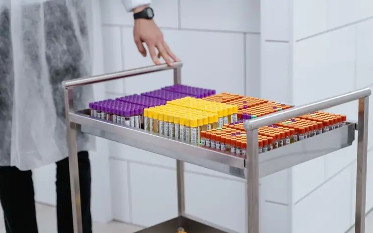 Row of laboratory test tubes with colored caps neatly arranged in a rack