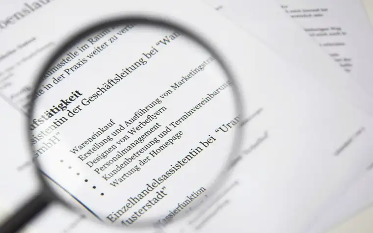 Black-framed magnifying glass over lines of printed text on paper