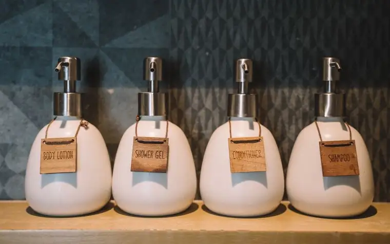 Amber pump bottles of skincare products lined up on a shelf